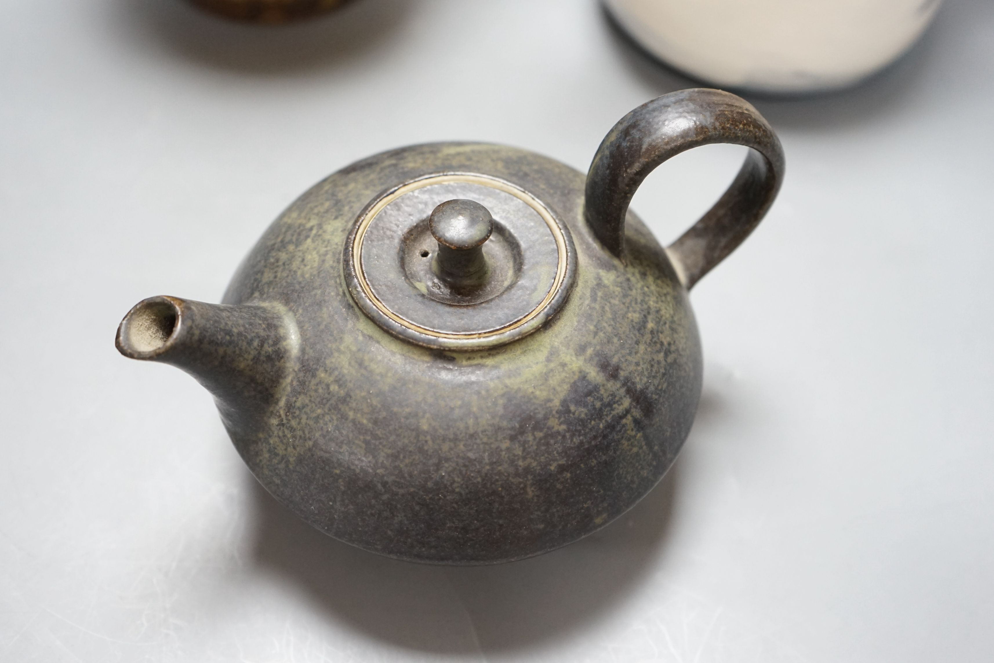 British studio pottery; a Jane Sawyer coffee pot and cover, Danlami Aliyu, for Wenford Bridge Pottery, pale green glazed stone were covered jug, and a black glazed white stoneware teapot, tallest 25cm, (3)